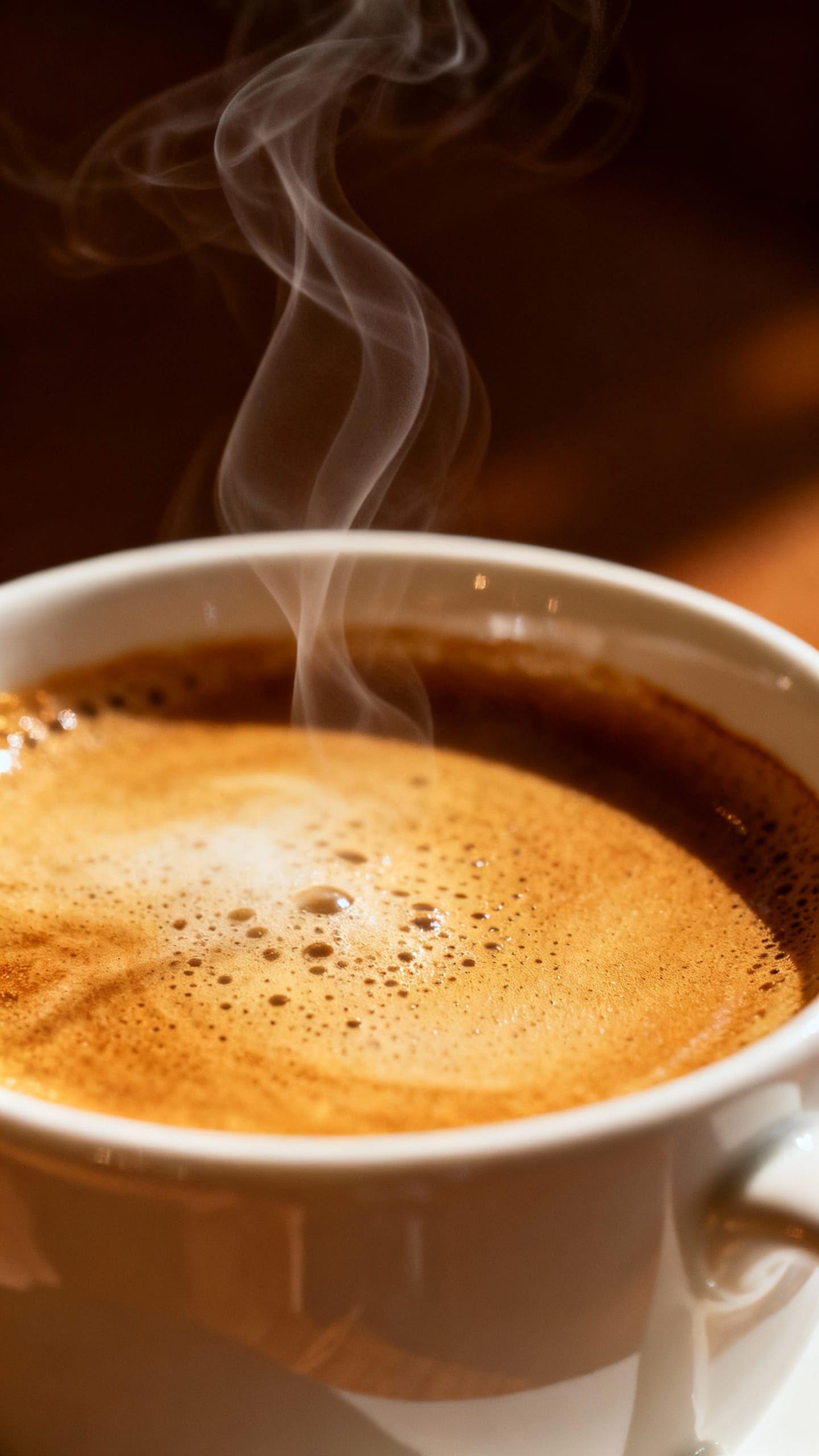 Closeup of steaming coffee poured into prewarmed white mug