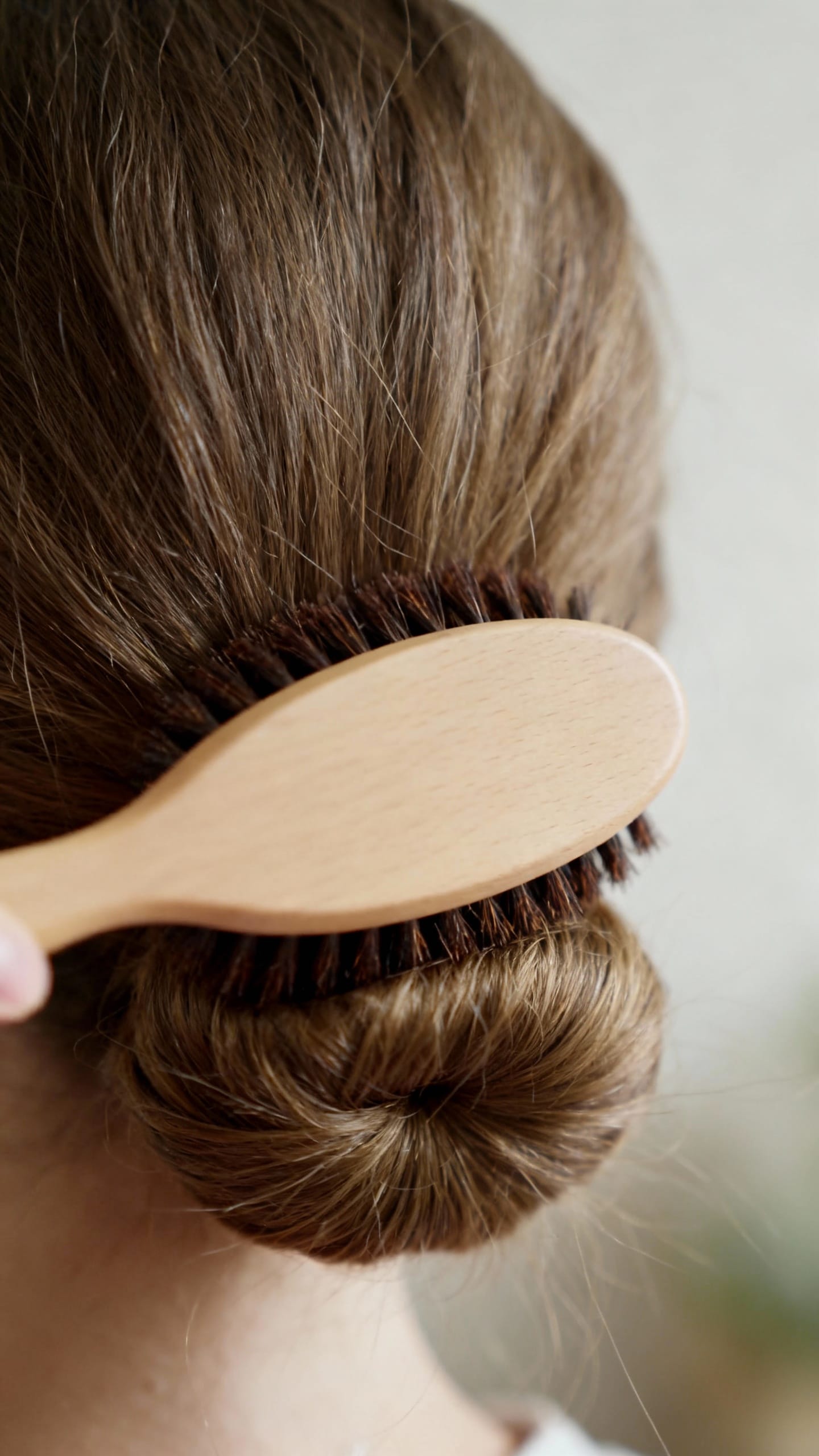 Macro shot boar bristle brush smoothing soft low bun