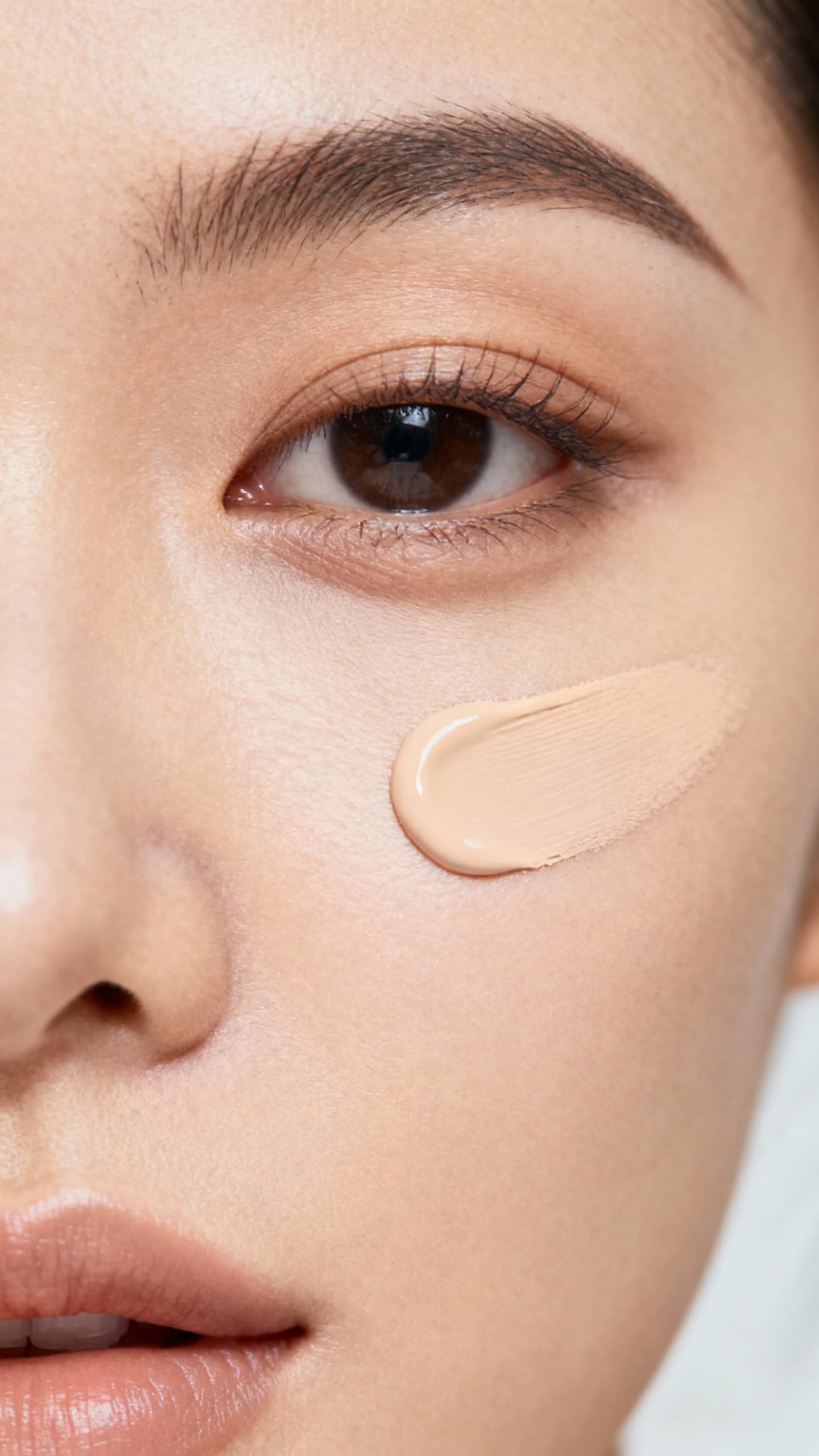 Macro shot of concealer dabbed at inner eye corner, soft-blended edges